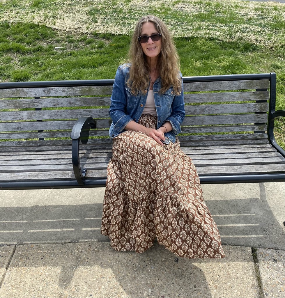 Jill K. Karkella sitting on a park bench, artist and founder of Willow Waves Art